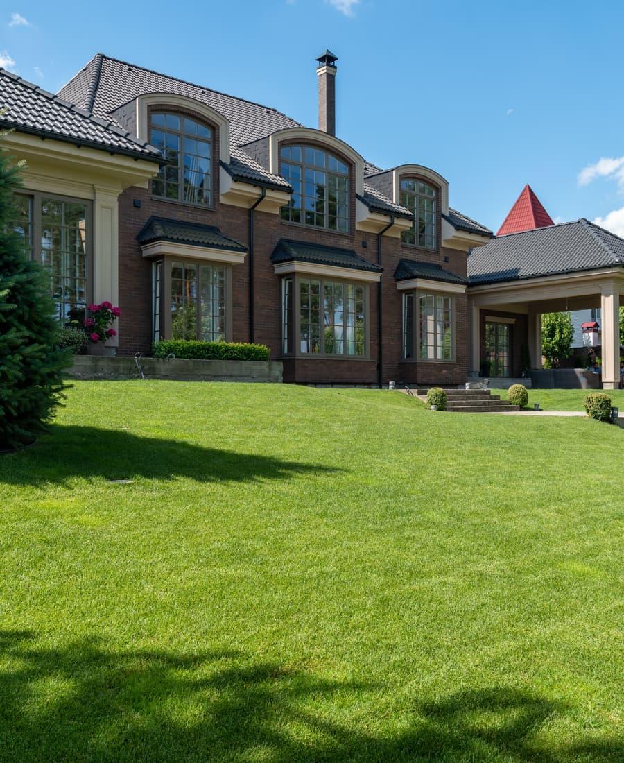 A beautifully maintained lawn in front of a large home